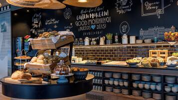A breakfast buffet area with various food items and a wall with inspirational quotes.