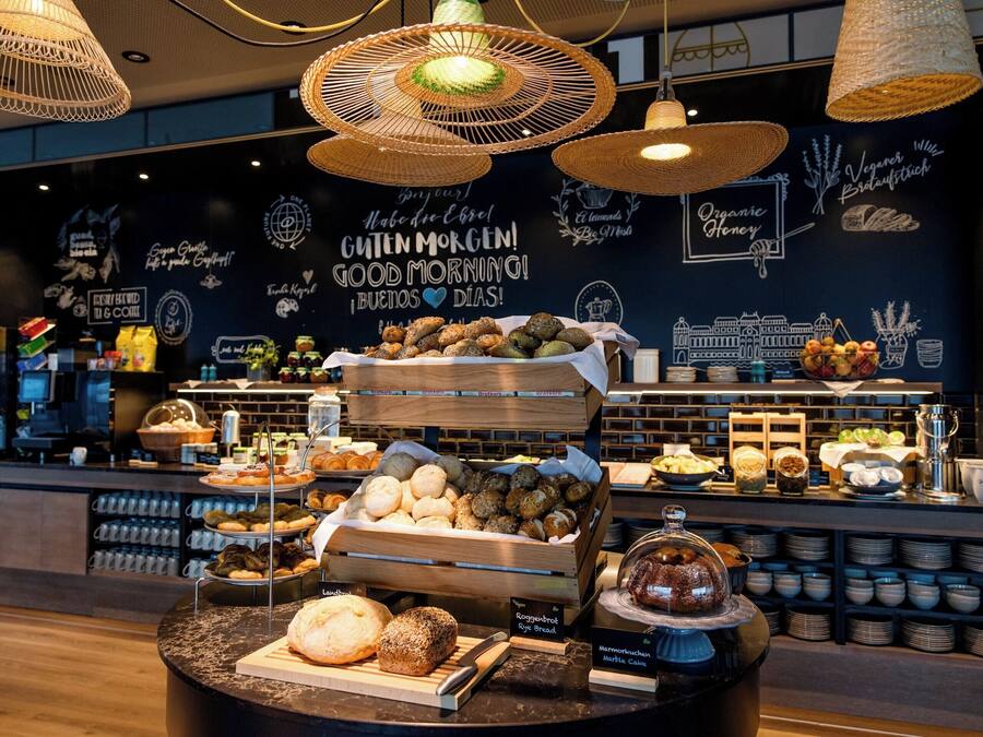 A bakery counter with various baked goods and a coffee station.