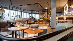 Un intérieur moderne avec des espaces salon, des tables et un bar.