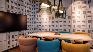 Een moderne eetruimte met een houten tafel, kleurrijke stoelen en hanglampen.