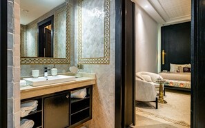 A modern bathroom with a large mirror, a sink, and a vanity with shelves.