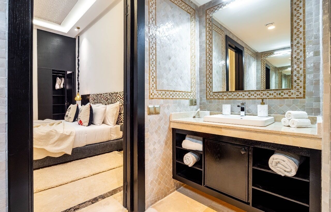 A modern bathroom with a large mirror, a sink, and a vanity with storage.