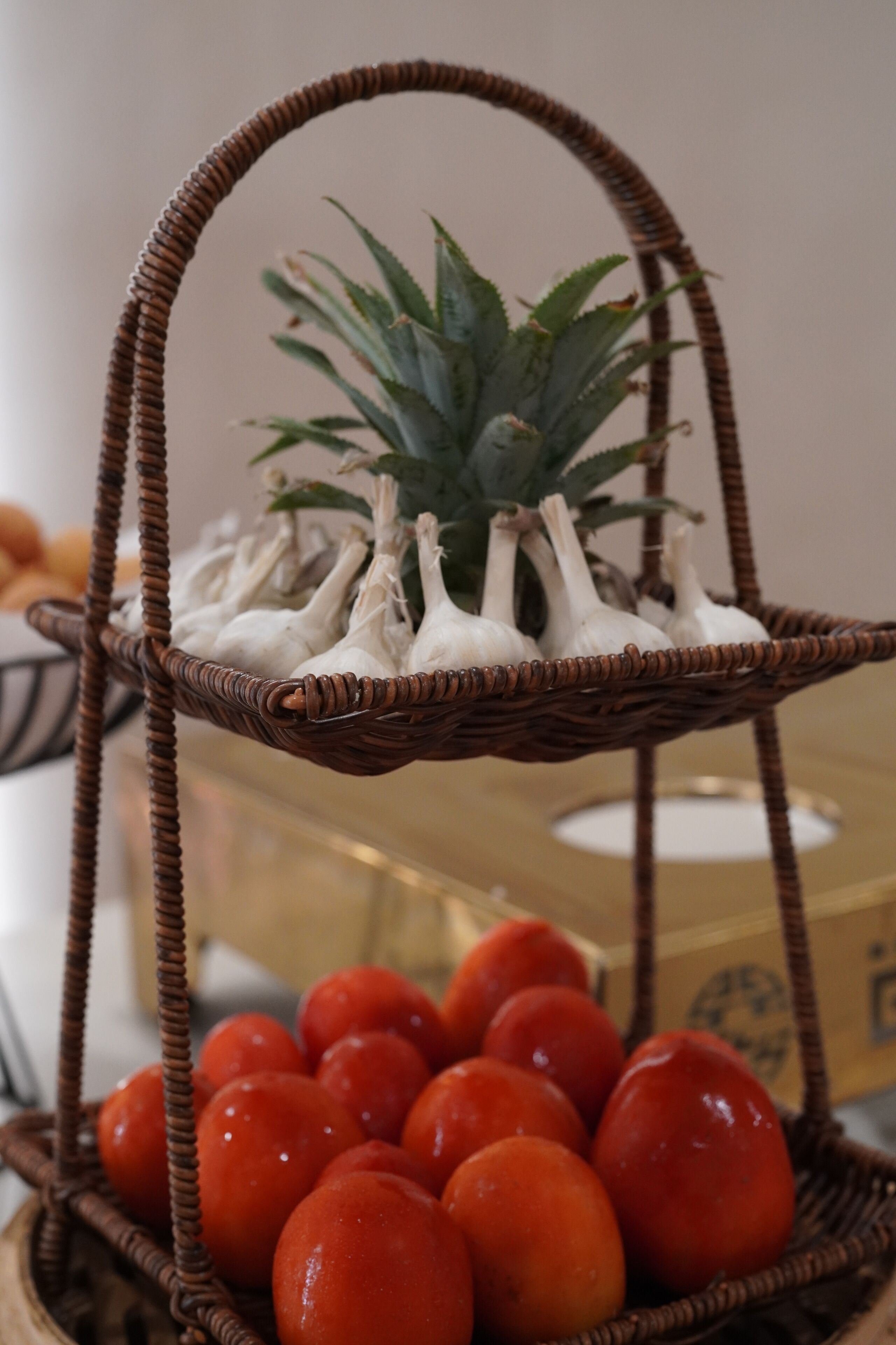 A wicker basket with white mushrooms and red tomatoes.