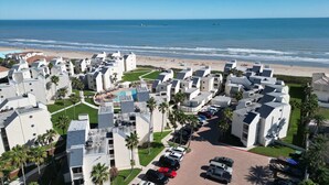 Una località balneare con architettura moderna, una piscina centrale e vista sulla spiaggia.