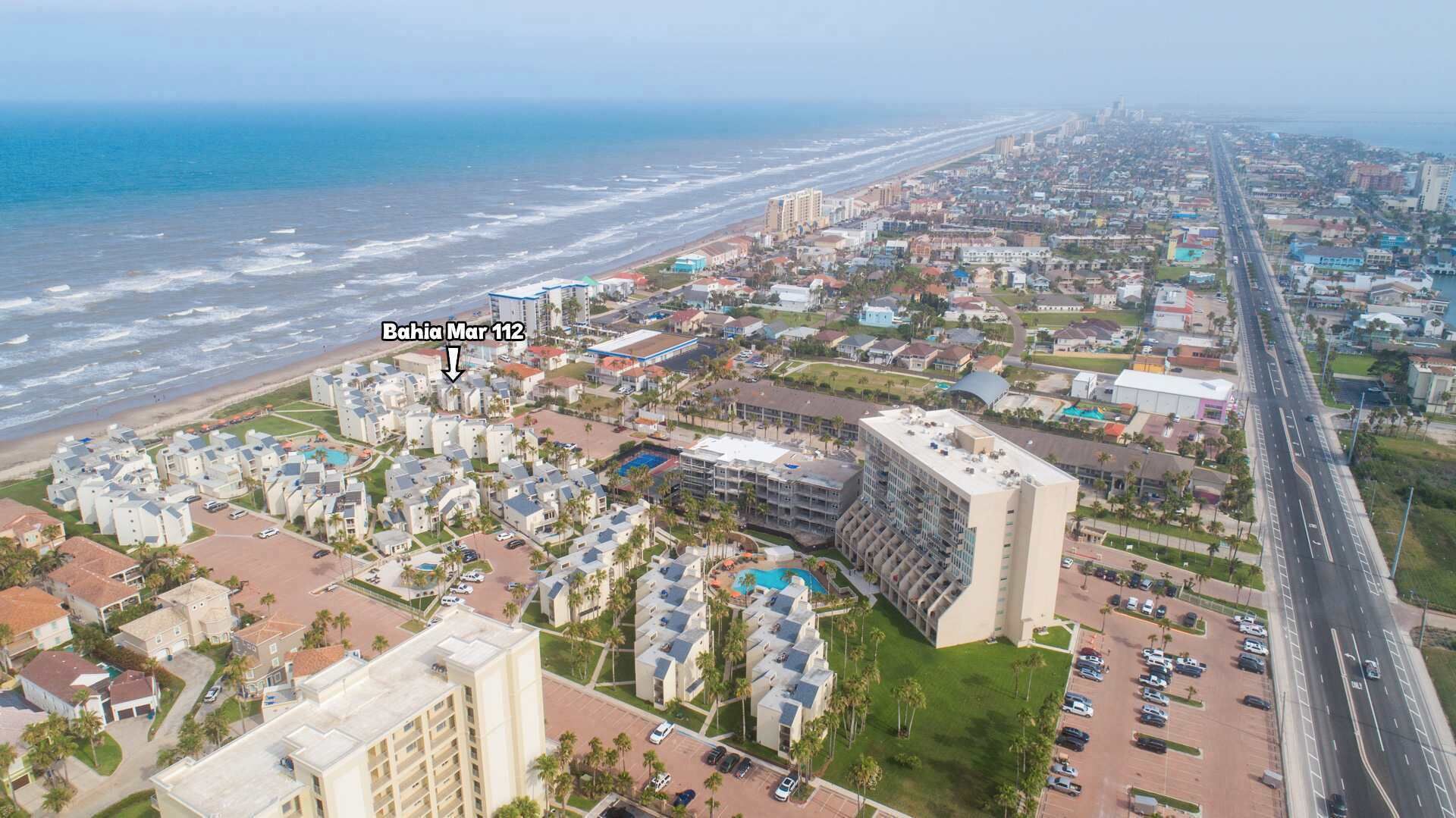 Luchtbeeld van een kustplaats met een strandhotel genaamd Bahia Mar 112.