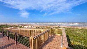 Un pontile in legno con ringhiera che si affaccia su una spiaggia.
