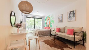 A modern living room with a sofa, dining table, chairs, and a hanging light fixture. - MOT Azcuenaga 1800 (Buenos Aires)