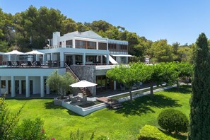 Une maison moderne à deux étages, dotée d’une piscine, d’un espace de détente extérieur et d’un jardin bien entretenu.