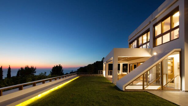 A modern house with a sloped roof, large windows, and a well-maintained lawn. - Villa Terra Creta Luxury Retreat and Spa (Chania)