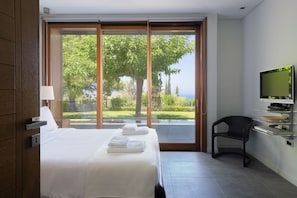 Une chambre d’hôtel avec un lit, un bureau avec un ordinateur, une chaise et un téléviseur.