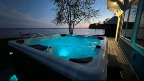 Un jacuzzi con vistas al agua y a un árbol.