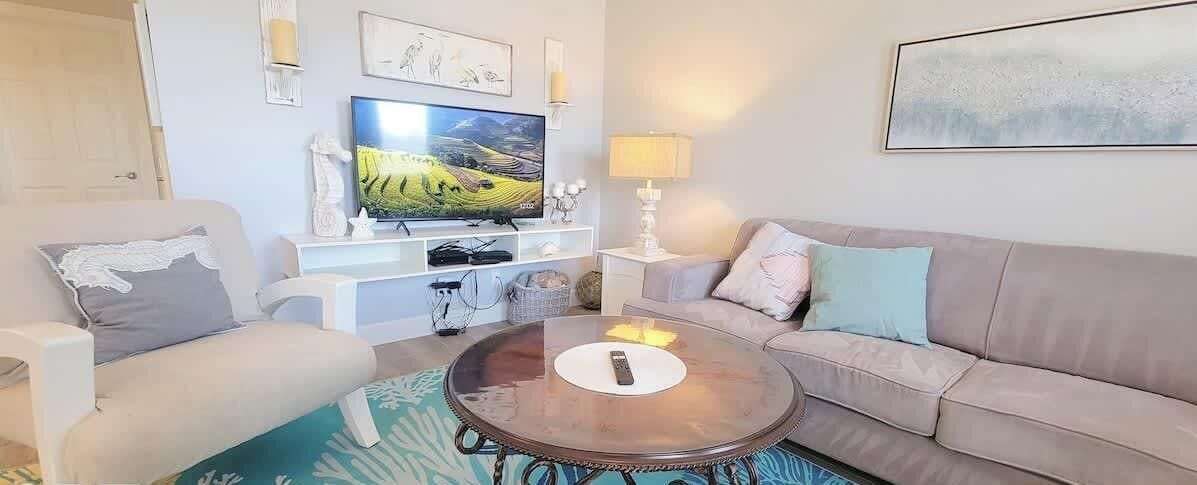 A living room with a TV, sofa, and coffee table.
