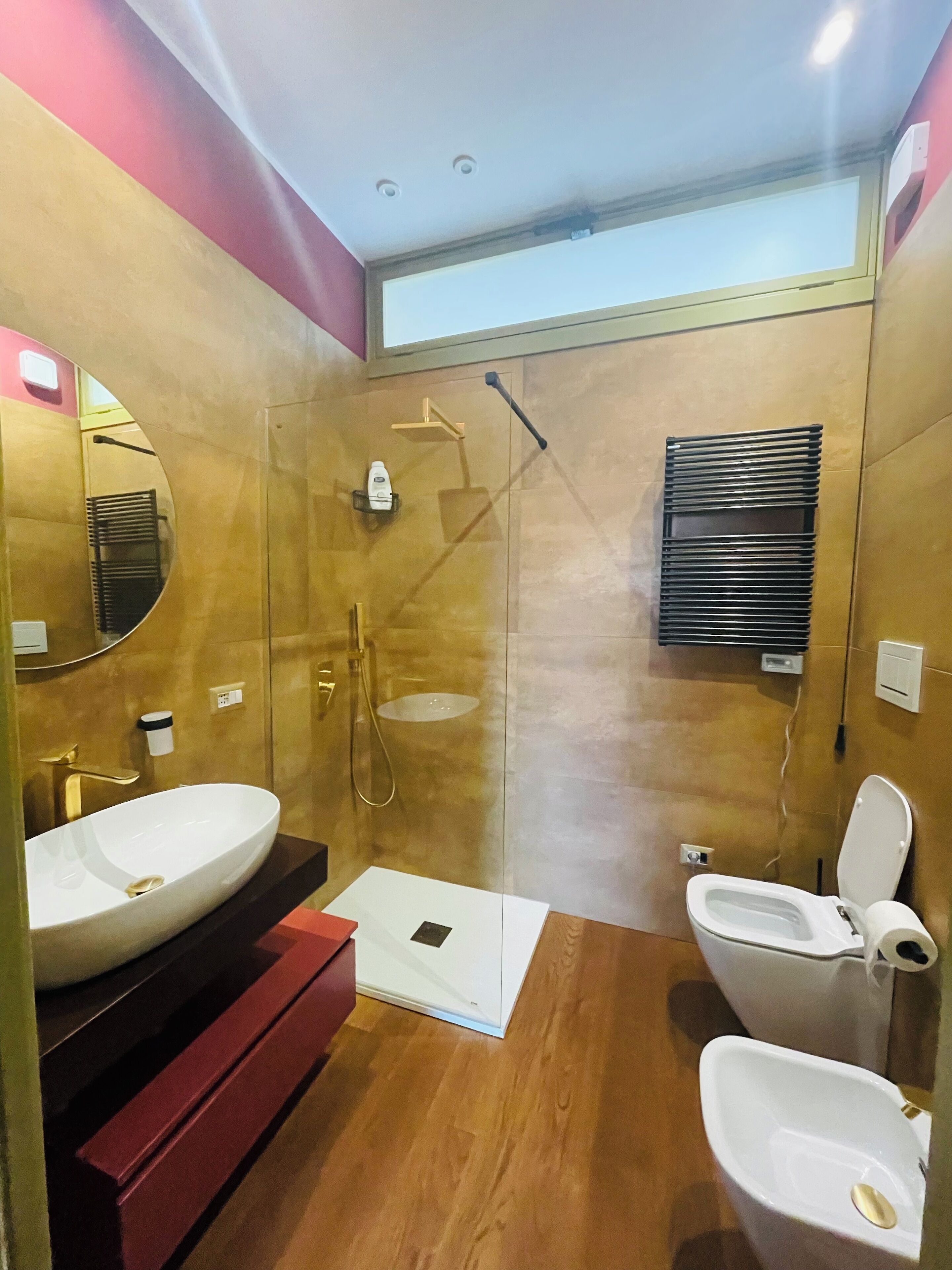 Ein modernes Badezimmer mit einem großen Spiegel, einem Waschbecken, einer Toilette und einer Dusche.