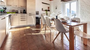 Eine moderne Küche mit Holzschränken und einem Essbereich mit Holztisch und Stühlen.