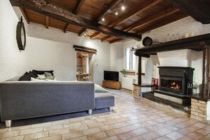 A cozy living room with a fireplace, a sofa, and a television.