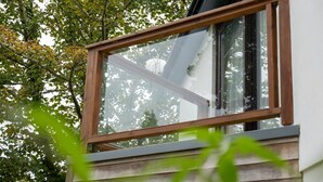 Une fenêtre dotée d’un cadre en bois, qui fait partie de la façade d’un bâtiment.