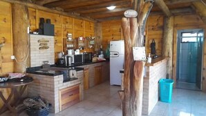 Una cabaña de madera rústica con cocina equipada con refrigerador, microondas y lavaplatos.