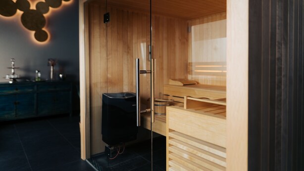 A modern kitchen with wooden cabinets, a built-in oven, and a black refrigerator. - The Kepos Hotel Erlangen (Erlangen)