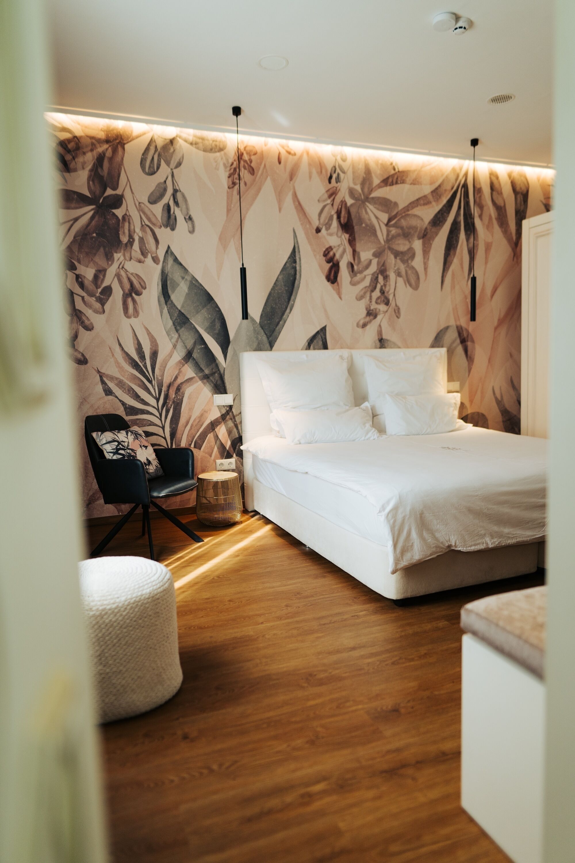 A modern bedroom with a bed, a chair, and a small round table.