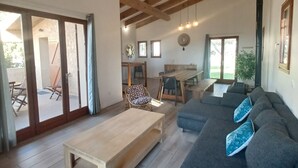 A spacious living room with a wooden ceiling, a large grey sofa, a wooden coffee table, and a dining area with a wooden table and chairs. - SEASIDE VILLA PADULINA WITH SWIMMING POOL (Galéria)