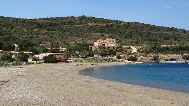 A coastal area with a sandy beach, a large building with multiple floors, and a hilly background. - SEASIDE VILLA PADULINA WITH SWIMMING POOL (Galéria)