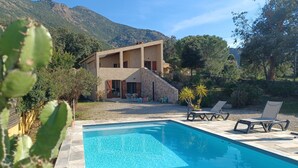 A poolside area with a pool, lounge chairs, and a stone building with a balcony. - SEASIDE VILLA PADULINA WITH SWIMMING POOL (Galéria)