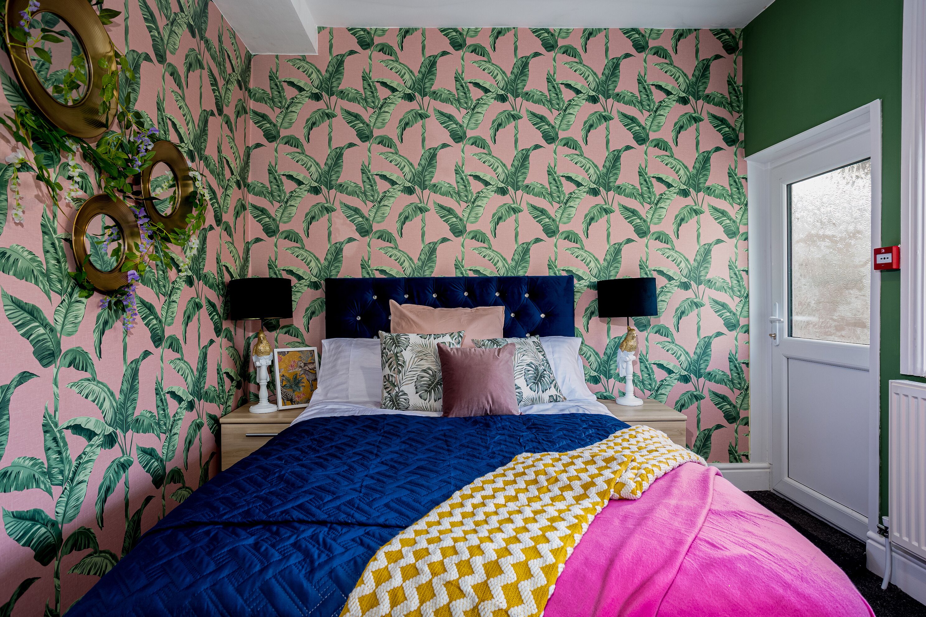 A bedroom with a bed, nightstands, and a window.