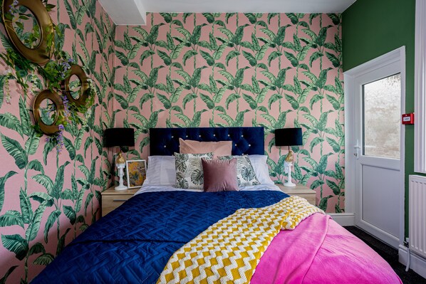 A bedroom with a bed, nightstands, and a window.