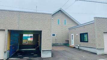 A building with a garage entrance, a small window, and a door.