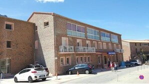 A two-story building with a brick facade, a balcony on the upper floor, and a sign that reads "MEDITERRANEES".