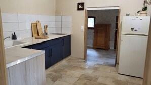 A kitchen with a sink, wooden cutting board, and a refrigerator. - Cottage rental Gaillac countryside (Técou)