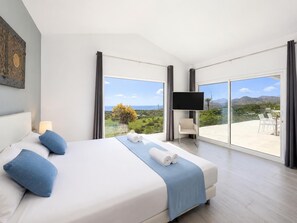 Een moderne hotelkamer met een groot bed, een flatscreen-tv en een balkon met een prachtig uitzicht.