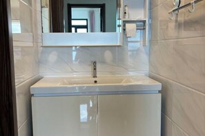 A bathroom with a white sink, mirror, and cabinet. - Seaview 2B2R 6pax Condo Forest City C5-2404 (Gelang Patah)
