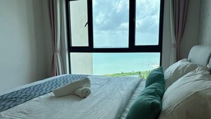 A bed with a view of the sea through a window. - Seaview 2B2R 6pax Condo Forest City C5-2404 (Gelang Patah)