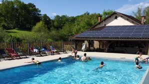 A swimming pool with people swimming and lounging.