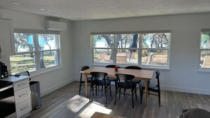 Una cocina moderna con comedor, ventanas amplias y vistas al exterior.