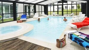 Ein Innenpool mit Liegestühlen und einem Whirlpool.