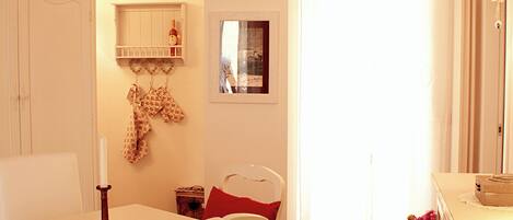 Un comedor con una mesa de madera, sillas y un armario blanco.
