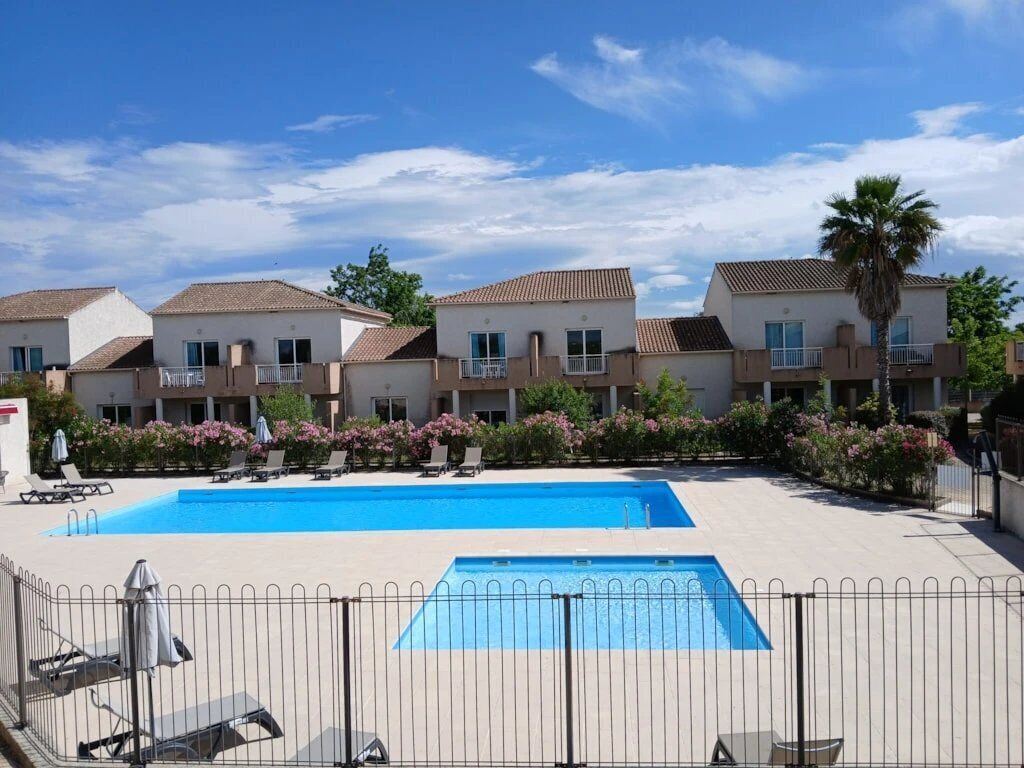 Un hôtel comprenant plusieurs bâtiments, une piscine et des espaces de détente en plein air.