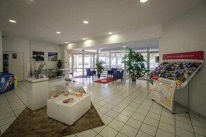 A spacious lobby with a reception desk, seating area, and informational displays.