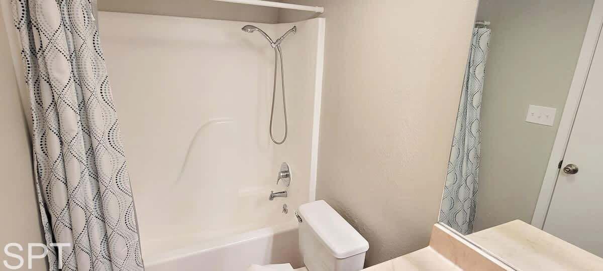 A bathroom with a bathtub, a shower, and a toilet.