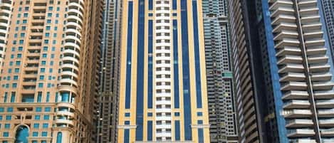 Un grand immeuble moderne, de style tour, doté d’un noyau central et de nombreux balcons.