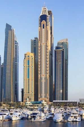 A marina with numerous yachts docked, surrounded by high-rise buildings with modern architecture.