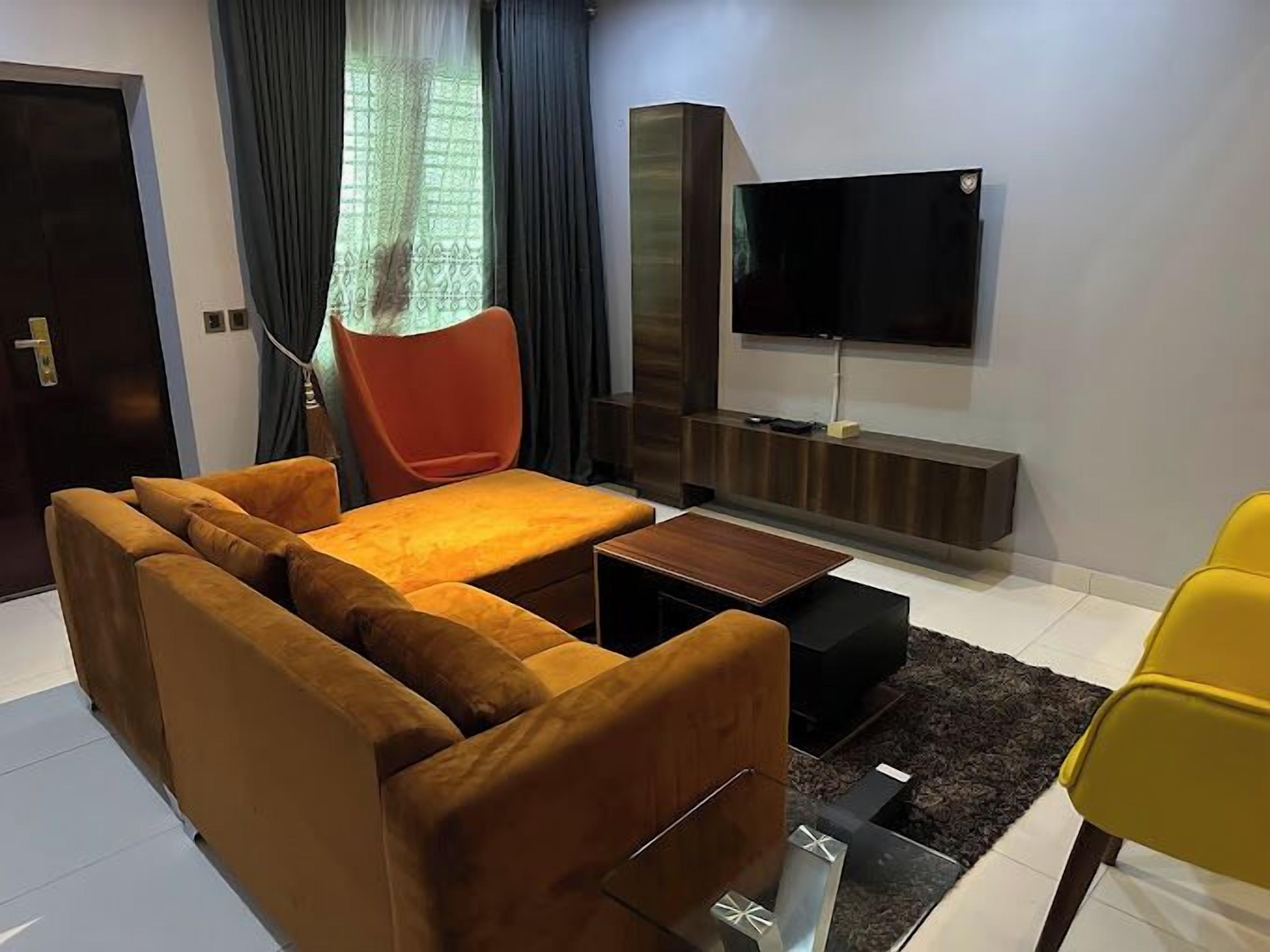 A modern living room with a sofa set, a coffee table, a TV, and a small side table.
