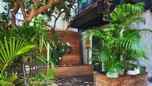 A courtyard with a brick bench, potted plants, and a tree. - homey stay and cafe by hematoa (Bangkok)