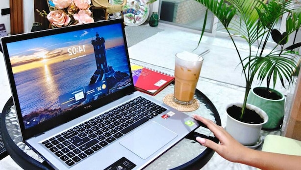 A laptop on a table with a glass of iced coffee, a notebook, and a potted plant. - homey stay and cafe by hematoa (Bangkok)