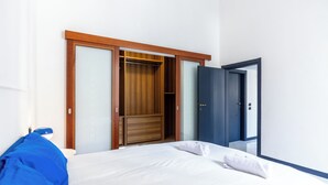 Une chambre d’hôtel avec un lit, une armoire et une porte.