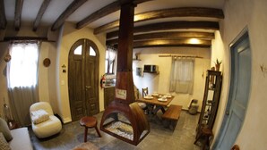 A cozy living room with a fireplace, a dining area, and a kitchen. - Vecchia Luna: Boutique Ground Floor, Val'Quirico. (Val'Quirico)