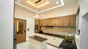 A modern kitchen with wooden cabinets, a central island, and a built-in dishwasher.