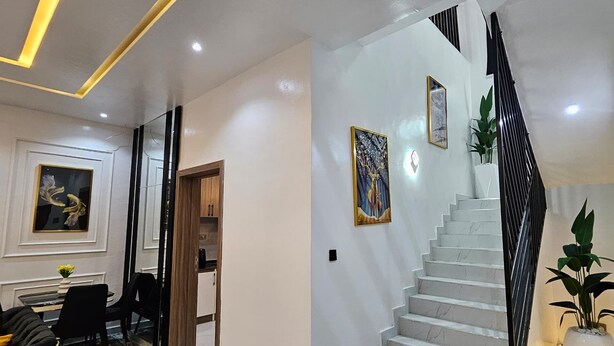 A modern interior with a staircase, a dining area, and a hallway.